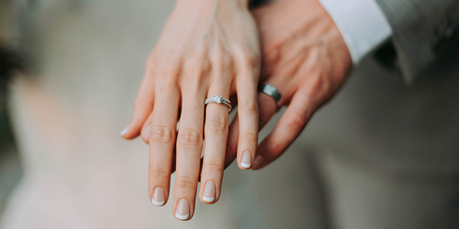 Photo of a bride and groom's hands with wedding rings