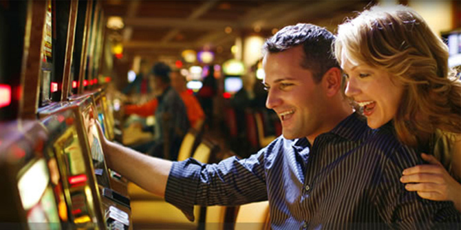 Picture of young couple playing slot machines